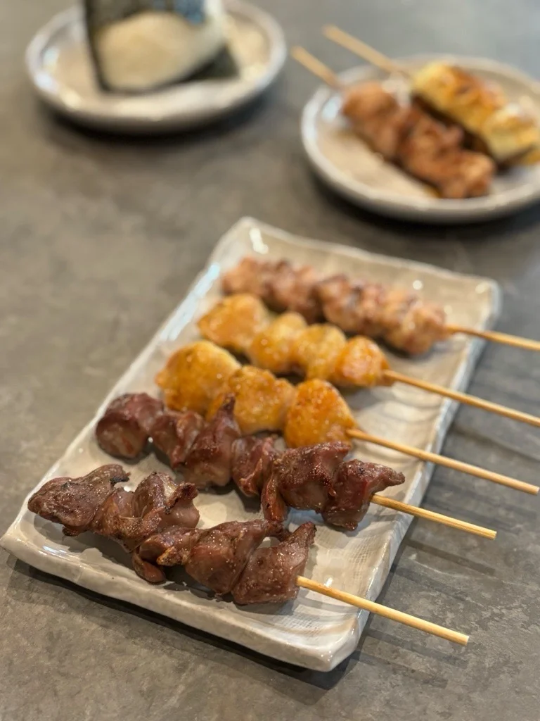 炭火で焼いた焼き鳥の盛り合わせを白い皿に並べた料理